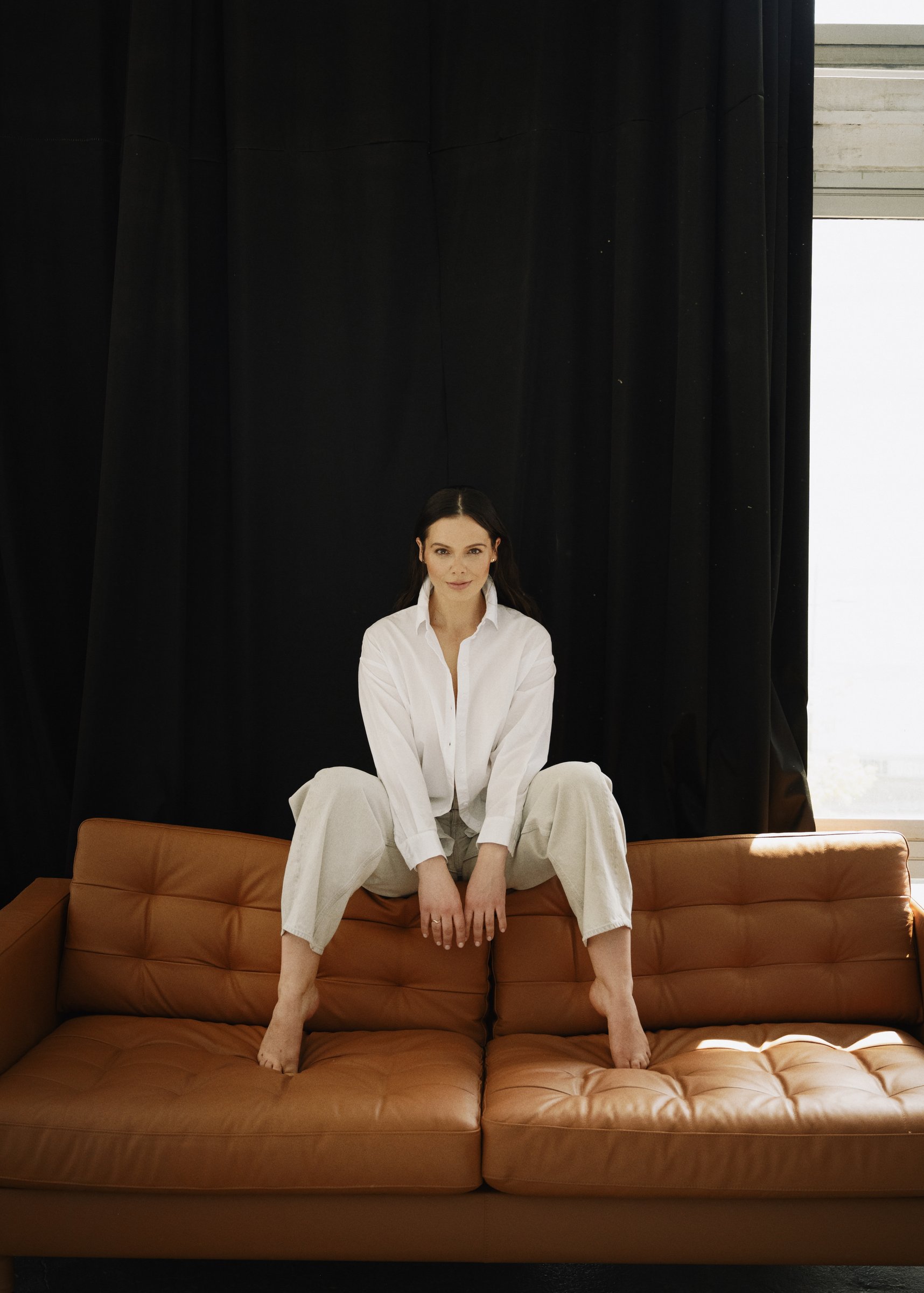 Edyta Maksimowicz sitting on a sofa, wearing a white shirt