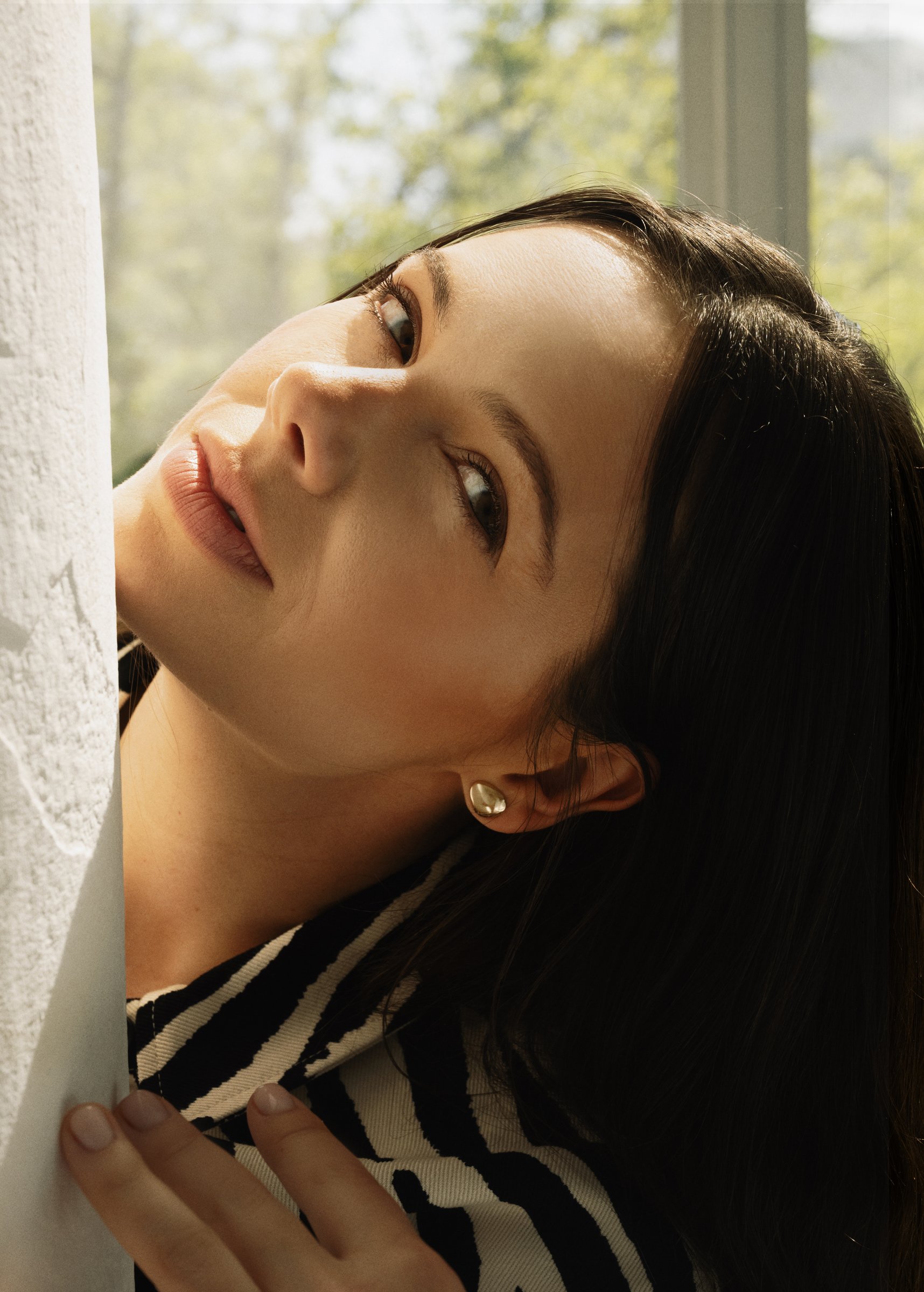 Edyta Maksimowicz by a window, wearing a striped shirt